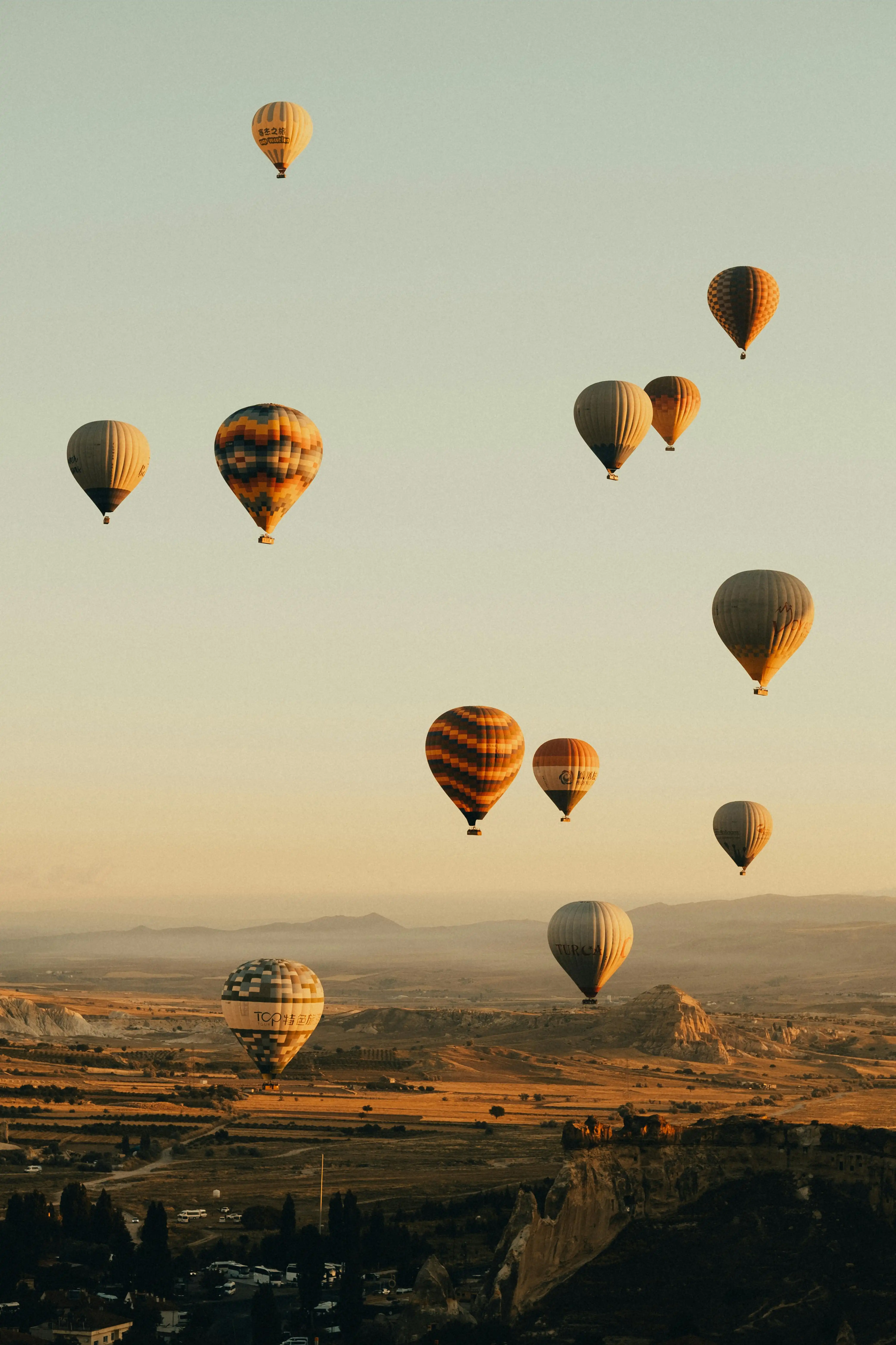 Hot airballoons taking off into the sky by Sami Aksu
