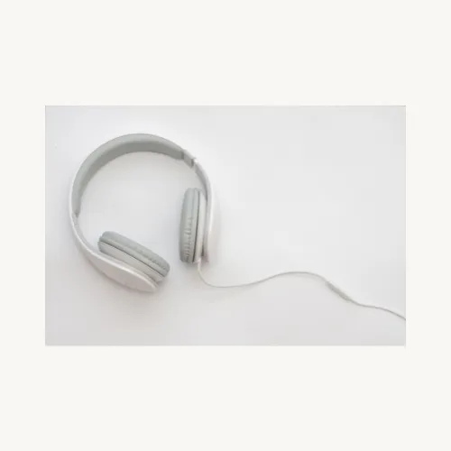 A wired headphone laying flat on a white surface.